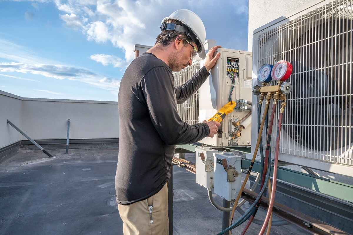 technician inspecting an HVAC unit technician inspecting an HVAC unit